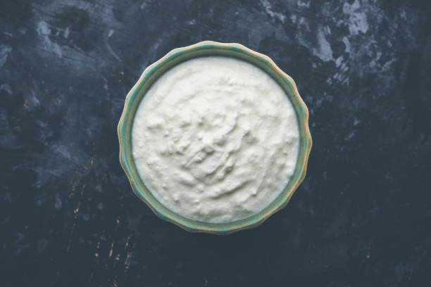 istock Plain curd or yogurt or Dahi in Hindi, served in a bowl over moody background. Selective focus 1049729754