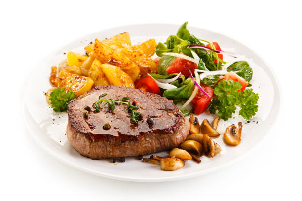 istock Grilled beefsteak, baked potatoes and vegetables on white background 1049732162