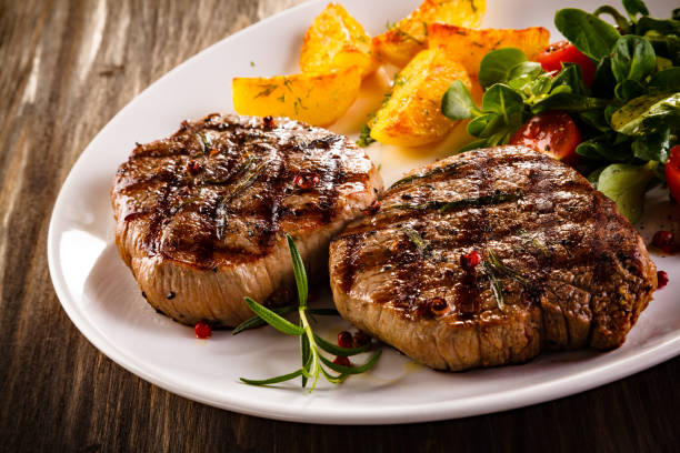 istock Grilled beefsteak, baked potatoes and vegetables on white background 1049732552