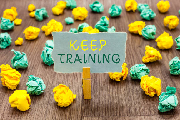 istock Text sign showing Keep Training. Conceptual photo Grounding Drilling Always Wonder Be Curious Learn Clothespin holding gray note paper crumpled papers several tries mistakes. 1049733084