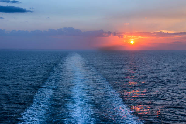 istock Sea horizon at sunset with ship wake. 1049733630