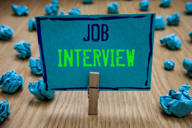 istock Handwriting text writing Job Interview. Concept meaning Assessment Questions Answers Hiring Employment Panel Clothespin holding blue paper note crumpled papers several tries mistakes. 1049735828