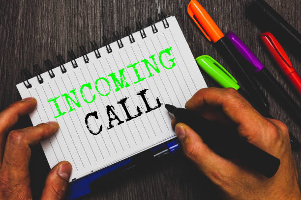 istock Handwriting text writing Incoming Call. Concept meaning Inbound Received Caller ID Telephone Voicemail Vidcall Man holding marker notebook paper communicating ideas Wooden background. 1049736736
