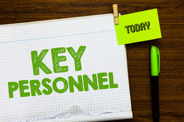 istock Writing note showing Key Personnel. Business photo showcasing Program Directors Principal Investigator Project Executives Open notebook page markers holding paper heart wooden background. 1049737426