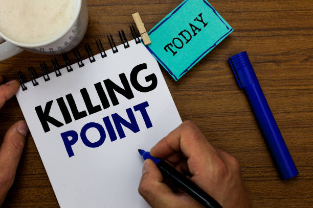 istock Writing note showing Killing Point. Business photo showcasing Phase End Review Stage Gate Project Evaluation No Go Man holding marker notebook clothespin reminder wooden table coffee. 1049738968