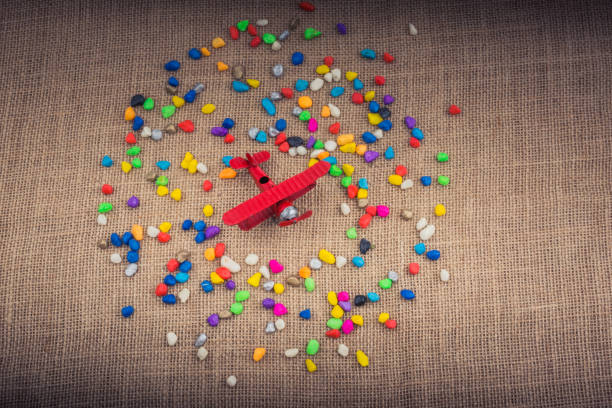 istock Airplane in hand amid colorful pebbles 1049739188