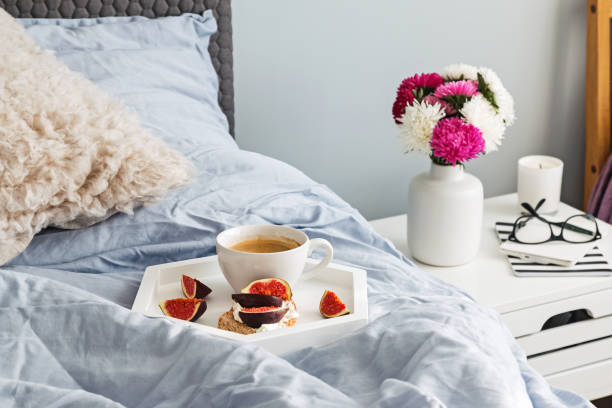 istock Tray with coffee and fig toast standing on the bed. 1049739580