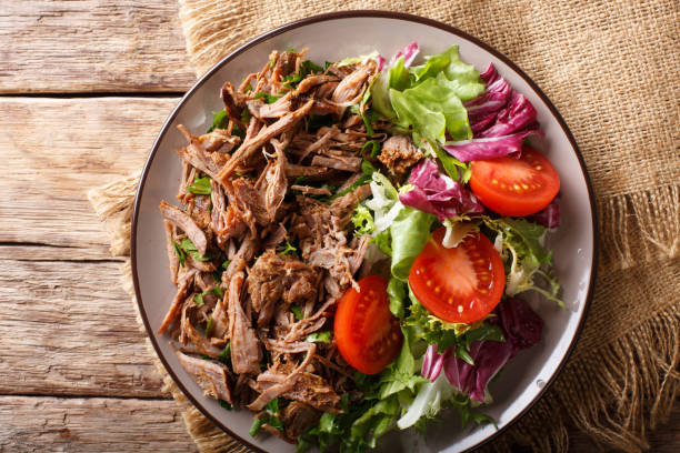 istock Healthy lunch: tender beef with vegetable salad close-up on a plate. horizontal top view from above 1049743364