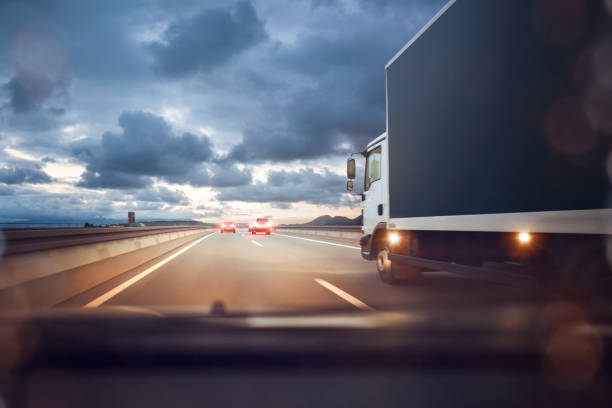 conducir en una carretera en el crepúsculo - rebasar fotografías e imágenes de stock