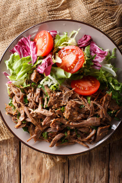 istock pulled spicy beef with fresh vegetables close-up on a table. Vertical top view from above 1049746522