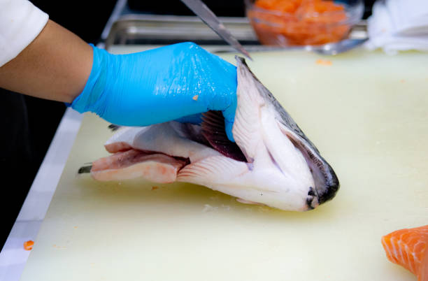 istock Chef cutting fresh salmon fillet in kitchen, chef cut the salmon 1049754380