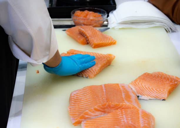 istock Chef cutting fresh salmon fillet in kitchen, chef cut the salmon 1049754506