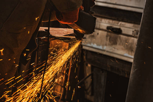 istock partial view of worker using circular saw with sparkles at factory 1049757836