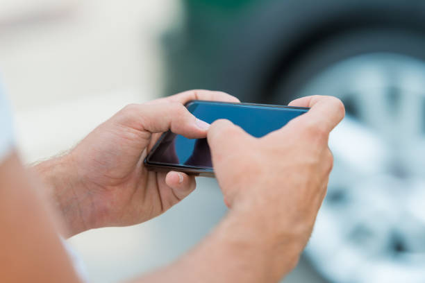 istock Man holding and typing text message on smart phone 1049762538