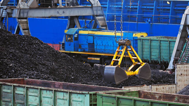 istock Sea cargo port operation. Industrial background. Loading coal into railway freight wagons, railroad. Cargo terminal, cranes and locomotive, panoramic view 1049765214