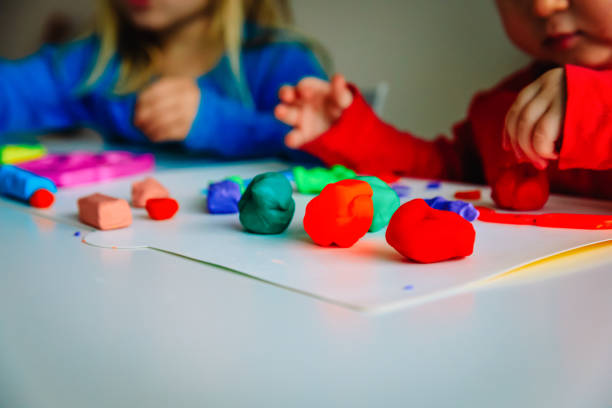 istock kids play with clay molding shapes, learning through play 1049768198