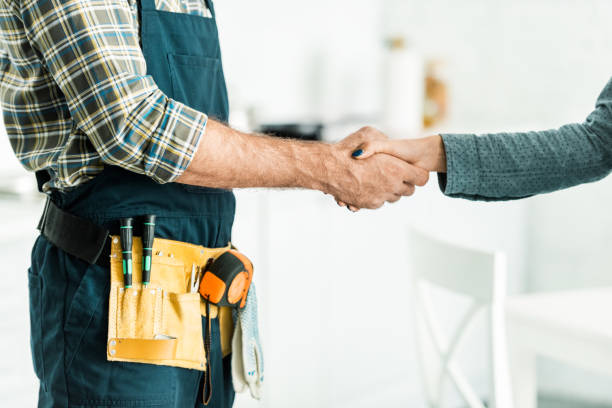 cropped image de plombier et mains tremblante client dans cuisine - work tool repairman tool belt hand tool photos et images de collection