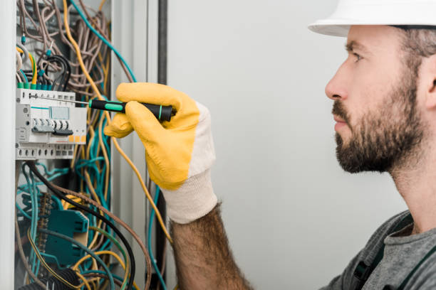 istock side view of handsome electrician repairing electrical box and using screwdriver in corridor 1049769260