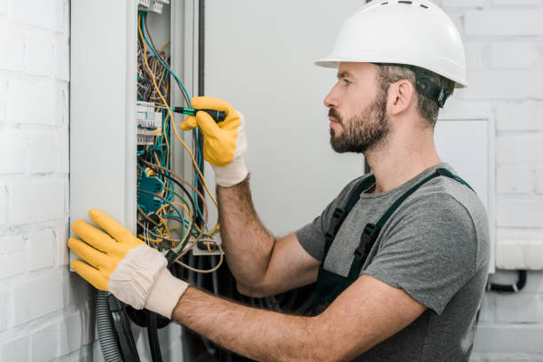 istock side view of handsome bearded electrician repairing electrical box and using screwdriver in corridor 1049769278