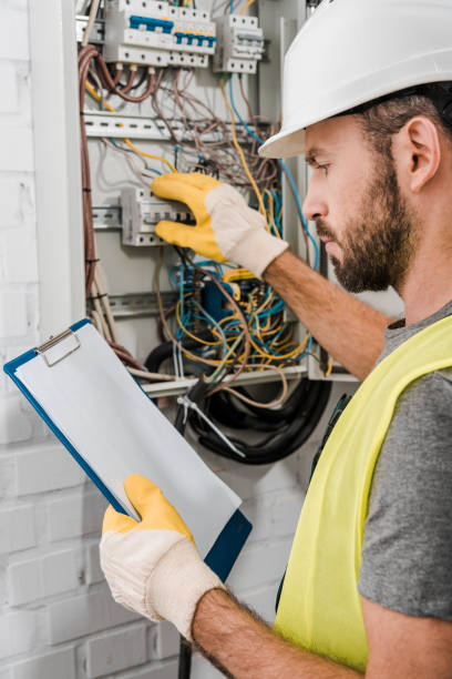 istock handsome electrician holding clipboard and checking electrical panel in corridor 1049769300