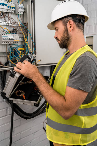 istock side view of handsome electrician holding toolbox near electrical box in corridor 1049771428