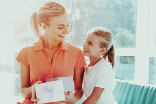 istock Little Daughter Is Giving A Present Box To Mum. 1049775088