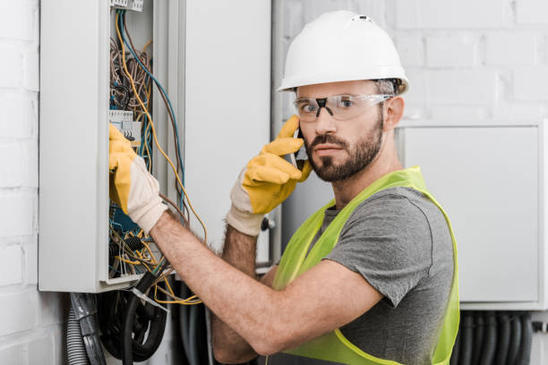 istock surprised electrician checking electrical box and talking by smartphone in corridor 1049775266