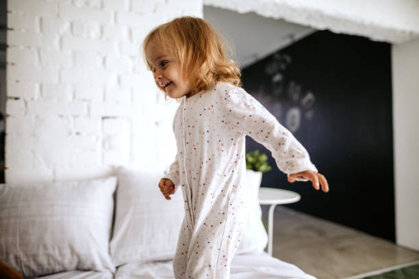 istock Cute girl jumping on the bed 1049778308