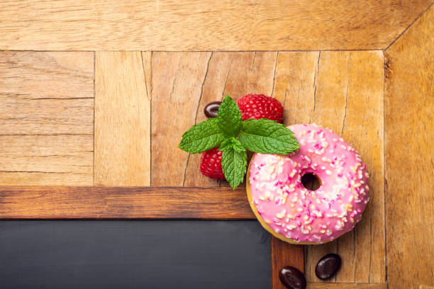 istock Black chalkboard with pink glazed donut 1049781470