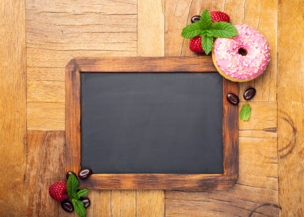 istock Black chalkboard with pink glazed donut 1049781512