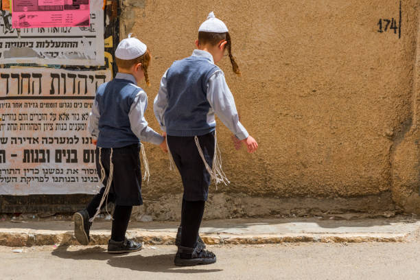 Ultra orthodox jewish boys walking on the street in Mea shearim Jewish Orthodox quarter, Israel Jerusalem. stock photo