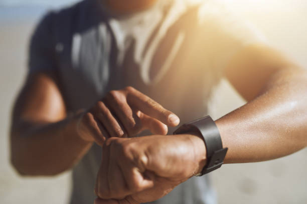 Let's see how I did today Closeup shot of an unrecognizable man checking his smartwatch while exercising outdoors tracker stock pictures, royalty-free photos & images