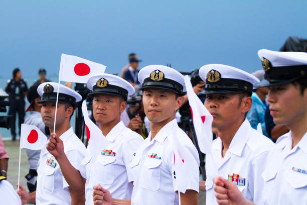 Row of walking japanese navy officers Row of walking japanese navy officers captured during asean fleet parade in Pattaya. Some officers are carrying small japanese flag. association of southeast asian nations photos stock pictures, royalty-free photos & images