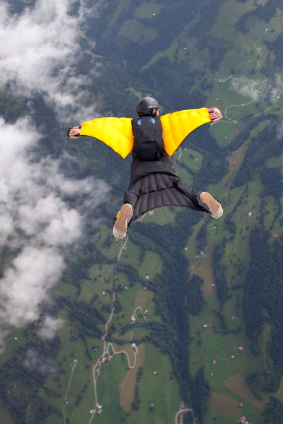 wingsuiter sunie w dół przez wzniosłe niebo - extreme sports confidence adventure danger zdjęcia i obrazy z banku zdjęć