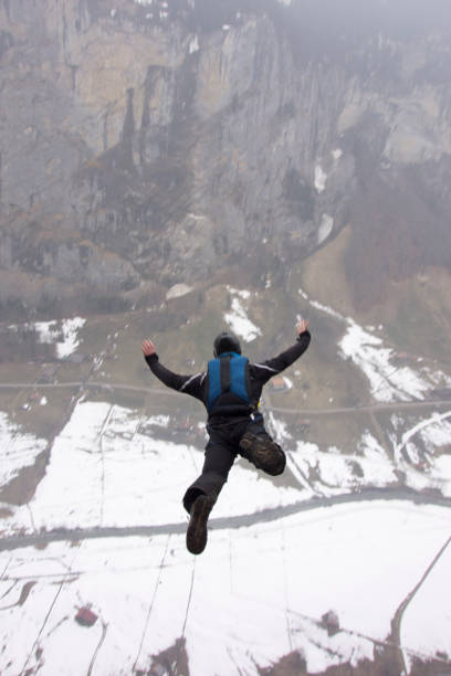 base jumper launches off cliff in the swiss alps - mountain drop europe switzerland imagens e fotografias de stock