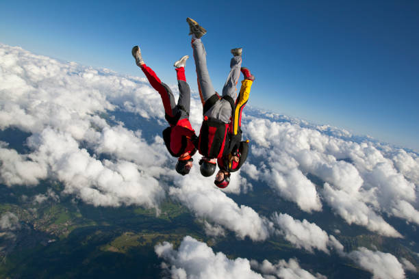 os para-quedistas mergulham através de sublimes céus acima de montanhas - skydiving parachute parachuting taking the plunge - fotografias e filmes do acervo