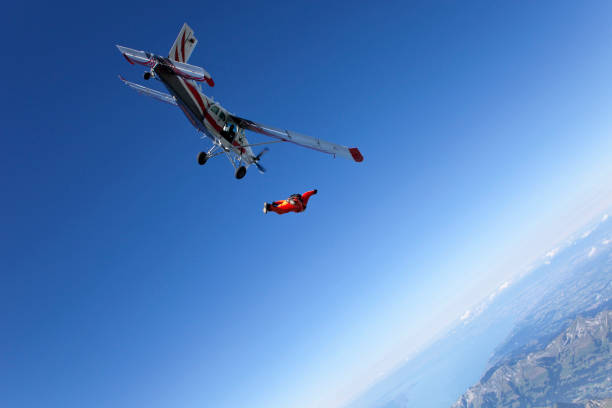 para-quedista mergulha para baixo abaixo de avião - skydiving parachute parachuting taking the plunge - fotografias e filmes do acervo