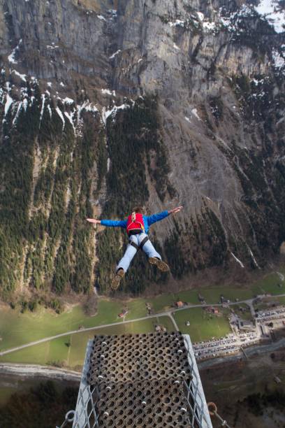 istock Base jumper launching off platform in the Swiss alps 1049791824