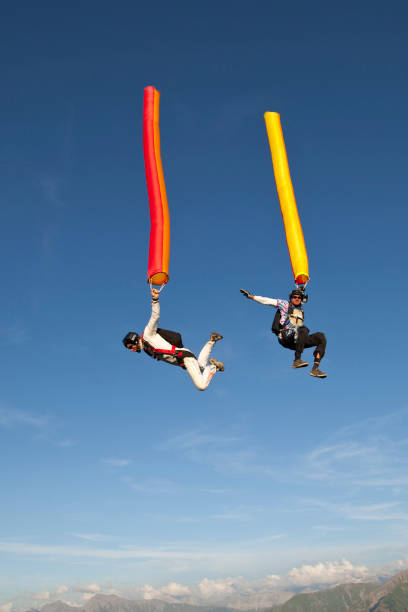 Skydivers plunge through lofty skies, holding kites