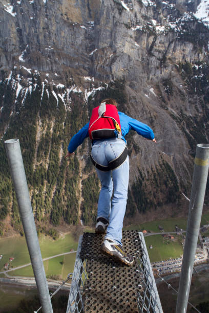 istock Base jumper launching off platform in the Swiss alps 1049791836