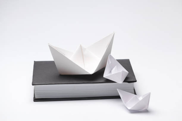 istock Origami paper boat on a book 1049798290