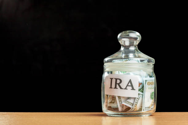 istock glass jar used for saving US dollar bills and notes for IRA retirement fund 1049798662