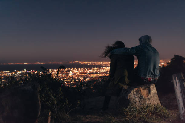 istock Rear view of couple sitting together on a tree trunk 1049807848