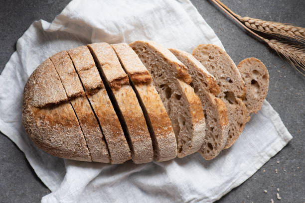 istock flat lay with cut loaf of bread on white linen on grey tabletop 1049808300