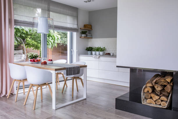 istock Real photo of a dining table, chairs and kitchen interior. Storage for fireplace wood. Empty wall, place for your poster 1049811188