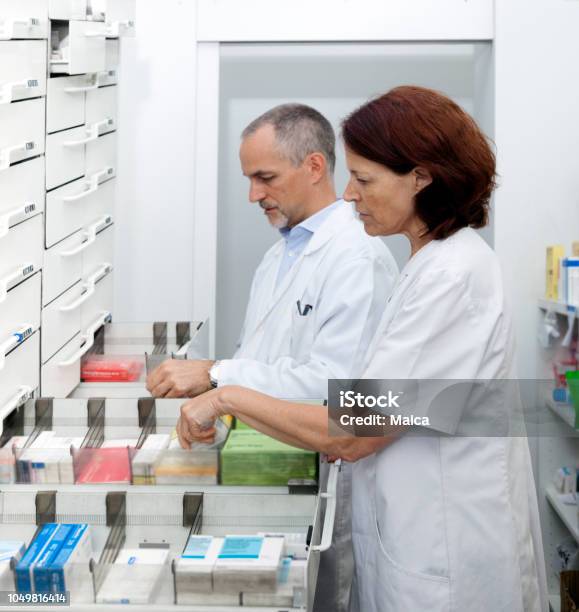 Pharmacists Organizing Medicines Stock Photo - Download Image Now - Pharmacy, Hospital, Adult