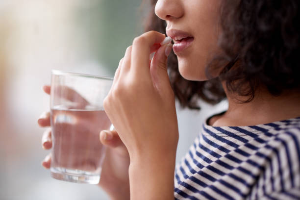 This will make me feel better Cropped shot of an unrecognizable teenage girl drinking medication birth control pill stock pictures, royalty-free photos & images