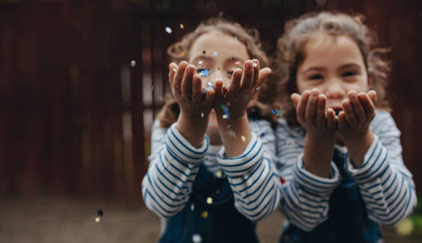 istock Twin sisters enjoying blowing glitter 1049824394