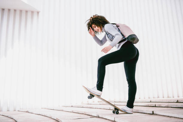 istock Cute Female Skater Making Skateboard Trick 1049824790