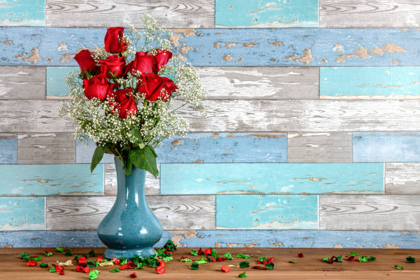 ヴィンテージの古い木製のバック ドロップで赤いバラの花瓶の排列を花します。 - rose dozen roses vase red ストックフォトと画像